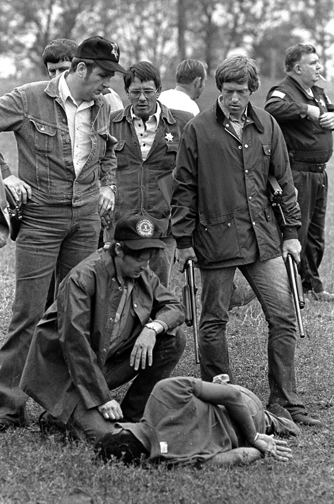 Minutes after firing a single rifle shot that ended the flight of fugitive Willie Joe Taylor, the sharpshooter kneels at his side.